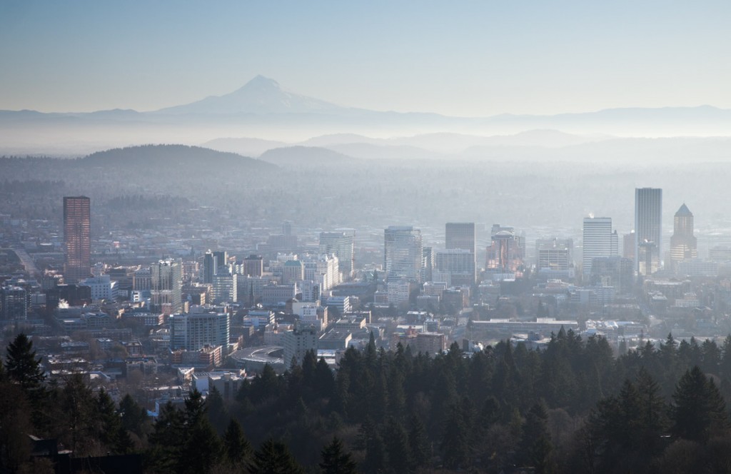 A view to the east on a hazy morning. Mt. Hood rises above the city skyline of Portland. The sun was reflecting off the buildings, giving a sort of back-glow.